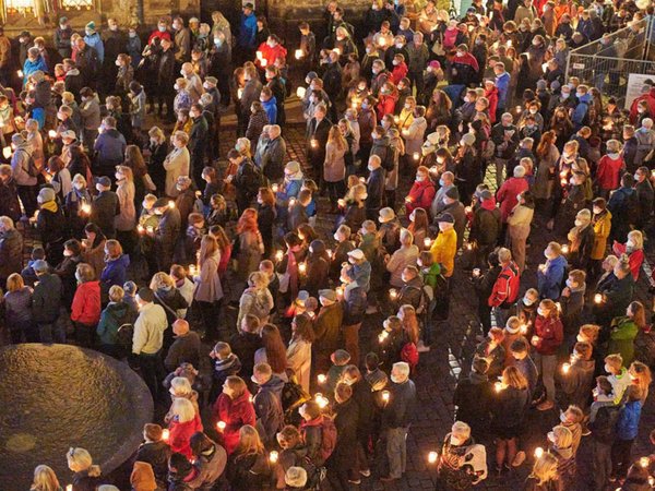 Emotionaler Moment beim Lichtfest Leipzig 2021 auf dem Nikolaikirchhof: Besucherinnen und Besucher mit Kerzen, Foto: LTM / PUNCTUM Esther Hoyer