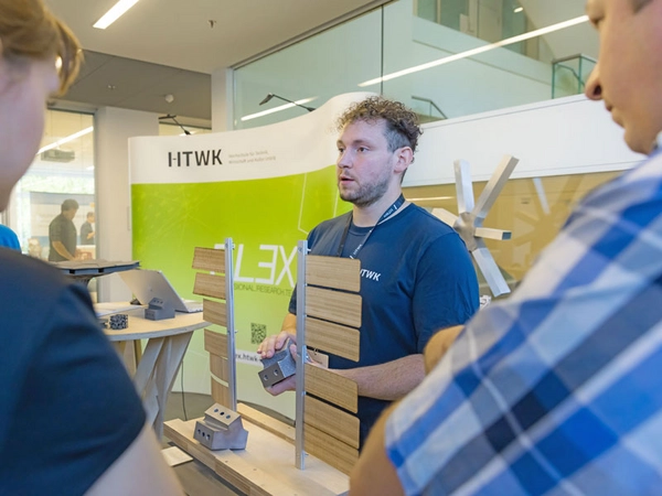 Martin Dembski von der HTWK-Forschungsgruppe FLEX erläutert während der EASTWOOD eine per 3D-Druck hergestellte Knotenverbindung, die Holzstäbe miteinander verbinden kann, Foto: Swen Reichhold / HTWK Leipzig