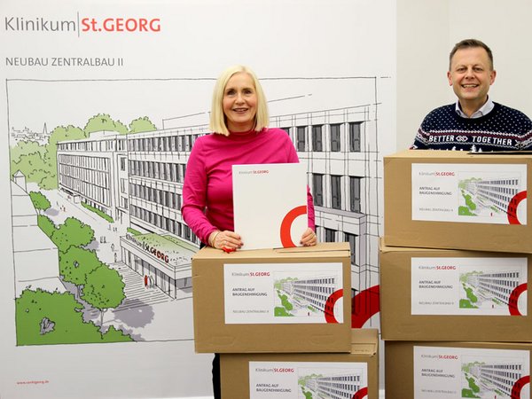 Dr. Iris Minde (Geschäftsführerin) und Torsten Bonew (Aufsichtsratsvorsitzender) mit gesamten Unterlagen zum größten Neubauprojekt in der Geschichte des Klinikums. Foto: Klinikum St. Georg, B. Hänsel