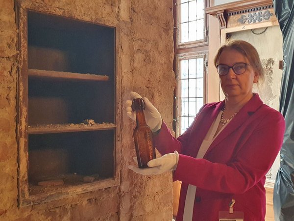 Ulrike Dura, stellvertretende Direktorin des Stadtgeschichtlichen Museums und Kuratorin für Kunstgeschichte, in der Ratsstube Altes Rathaus mit dem einmaligen Fundstück einer Bierflasche der Marke Riebeck, Foto: Stadtgeschichtliches Museum Leipzig