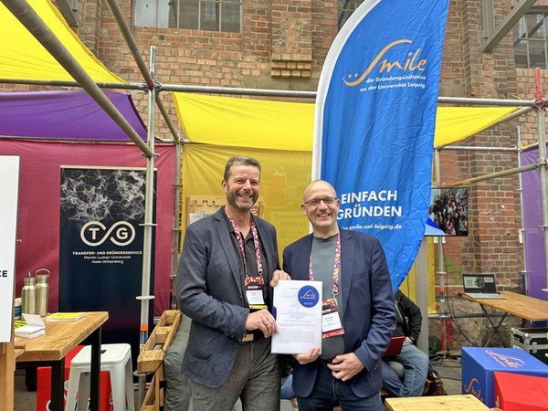 Frank Tappert (links) und Prof. Utz Dornberger besiegeln die Zusammenarbeit auf dem MACHN Festival. Foto: SMILE