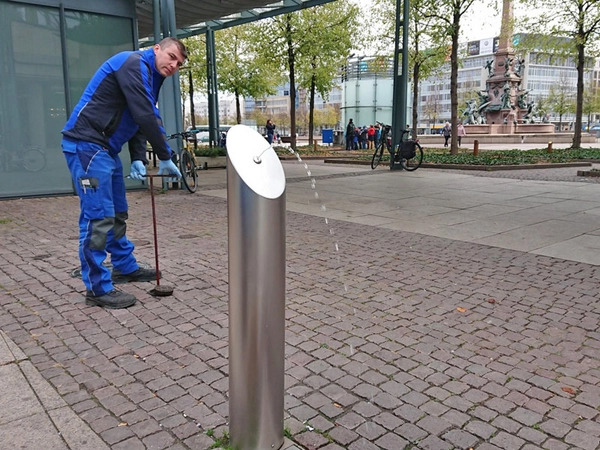 Vorarbeiter Rene Tannert schließt die Wasserzufuhr beim Brunnen auf dem Kurt-Masur-Platz. Rund 23.000 Liter gab der Brunnen seit seiner Inbetriebnahme Ende Mai aus, Foto: Leipziger Gruppe