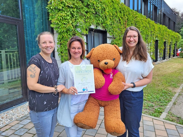 Manuela Bellmann (Mitte) mit Tochter und Ulrike Herkner präsentieren stolz den Spendenscheck vor dem Kinderhospiz Bärenherz, Foto: Kinderhospiz Bärenherz Leipzig